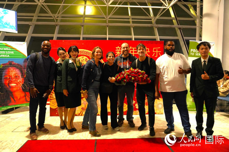 在埃塞航空春节庆祝活动现场,旅客们与埃塞航空中国籍员工合影留念。人民网记者 黄炜鑫摄