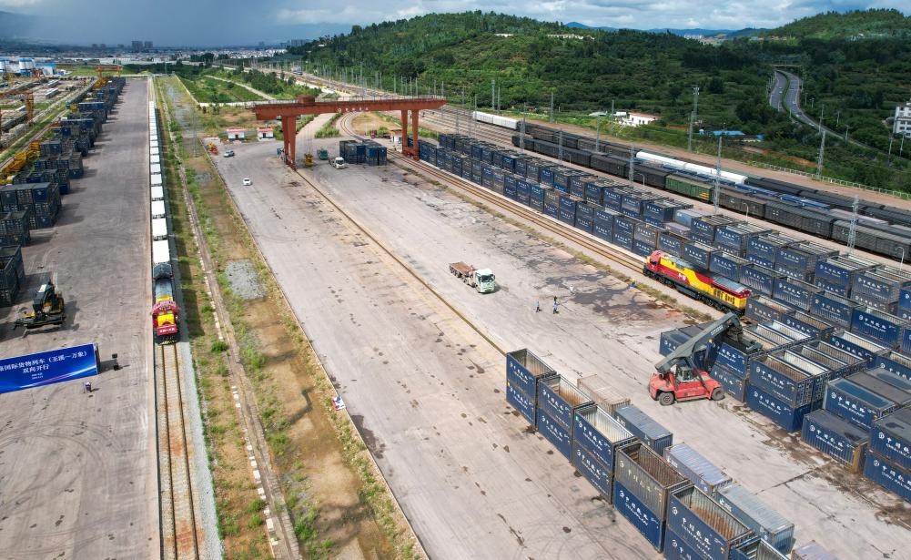8月23日,准备从玉溪发车的国际货物列车(左)、从老挝万象发车并已抵达的国际货物列车(右)同时停靠在中老铁路研和站(无人机照片)。新华社记者 陈欣波 摄